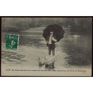   Man standing with umbrella on pontoon like boat,c1910
